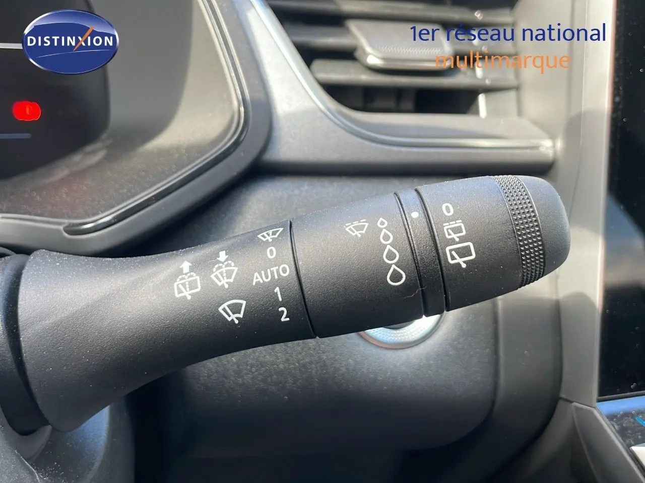 Gros plan sur la commande d'essuie-glace du Renault Captur E-Tech hybride 2025, intérieur noir avec détails gris.