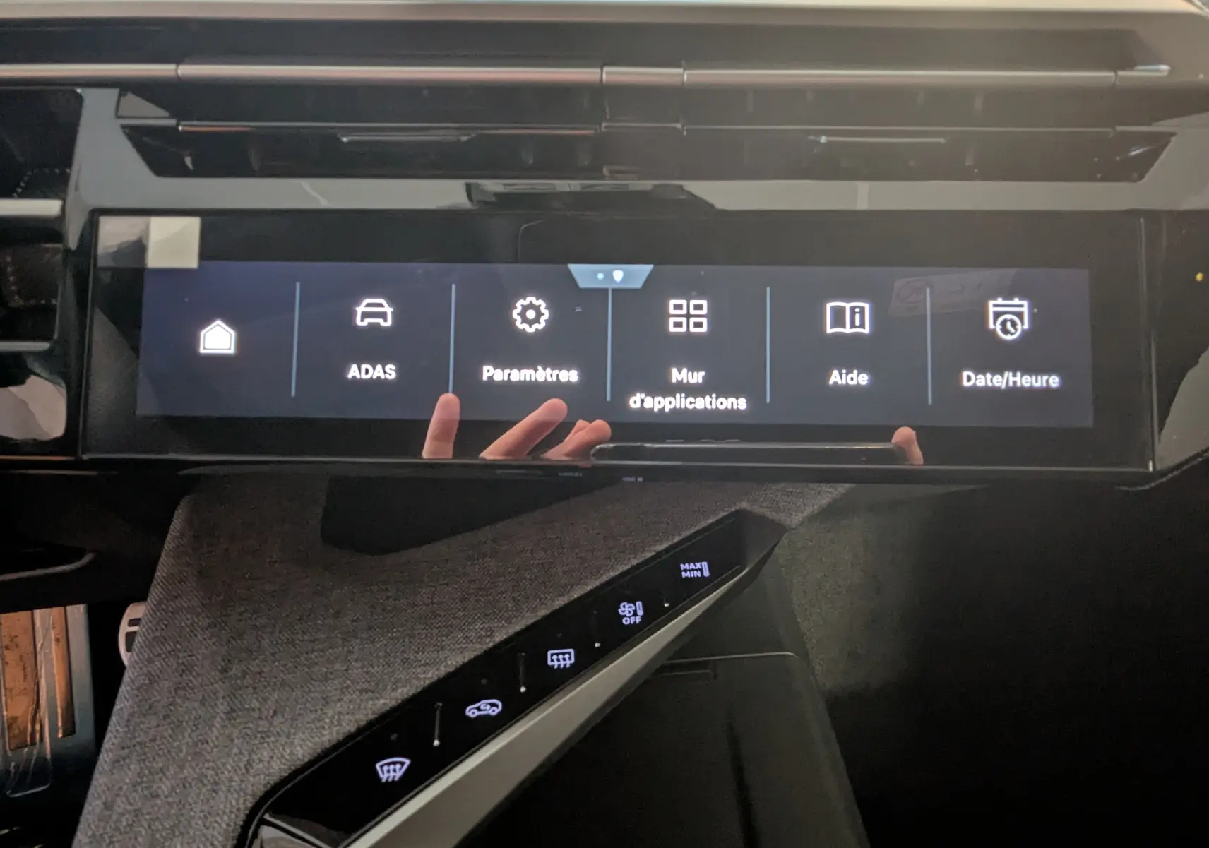 Vue rapprochée de l’écran tactile central du Peugeot 3008 Hybrid 145 GT avec interface en français et tissu gris sur la console.