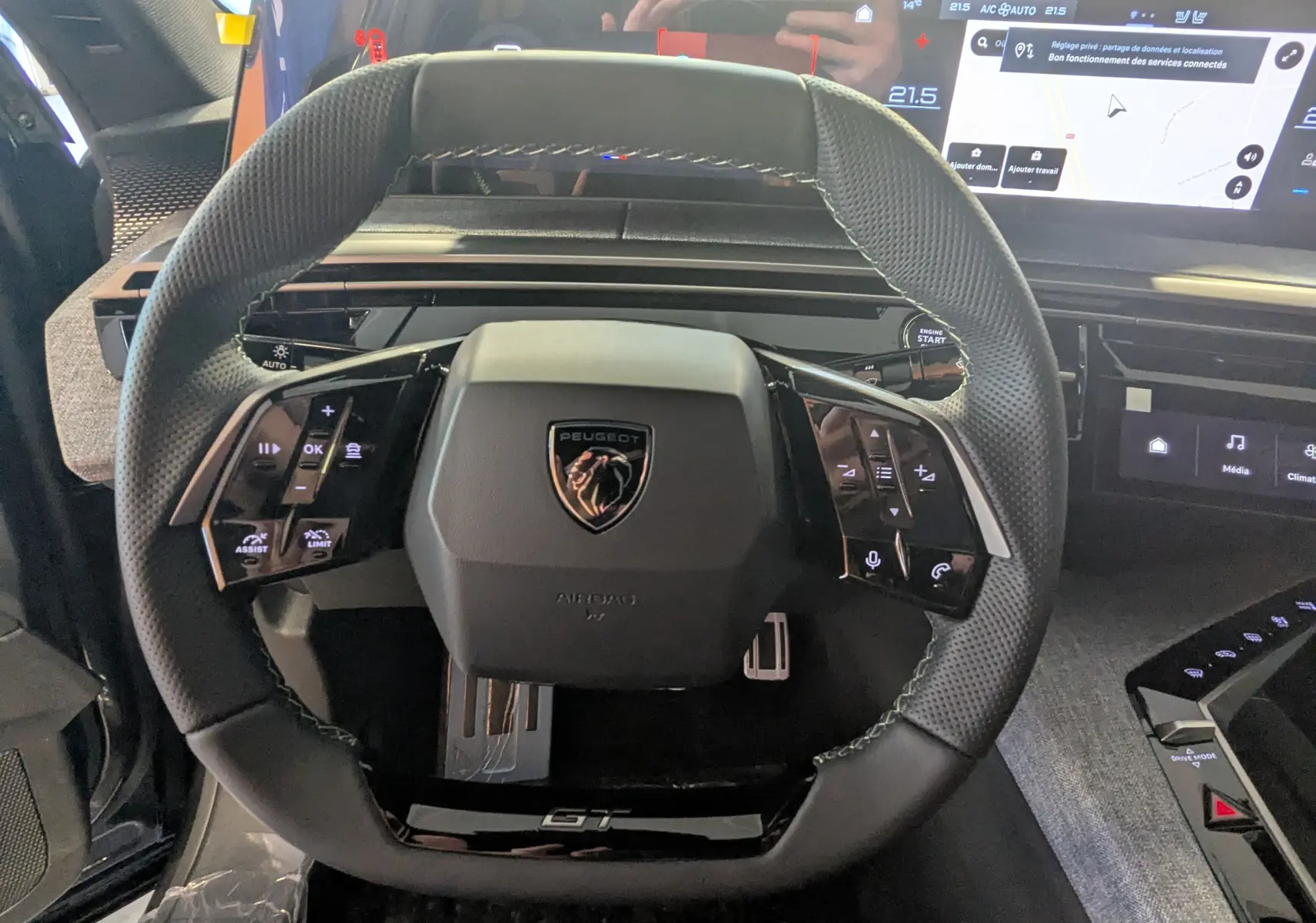 Vue rapprochée du volant cuir perforé noir avec logo Peugeot et tableau de bord numérique du 3008 HYBRID 145 GT 2025.