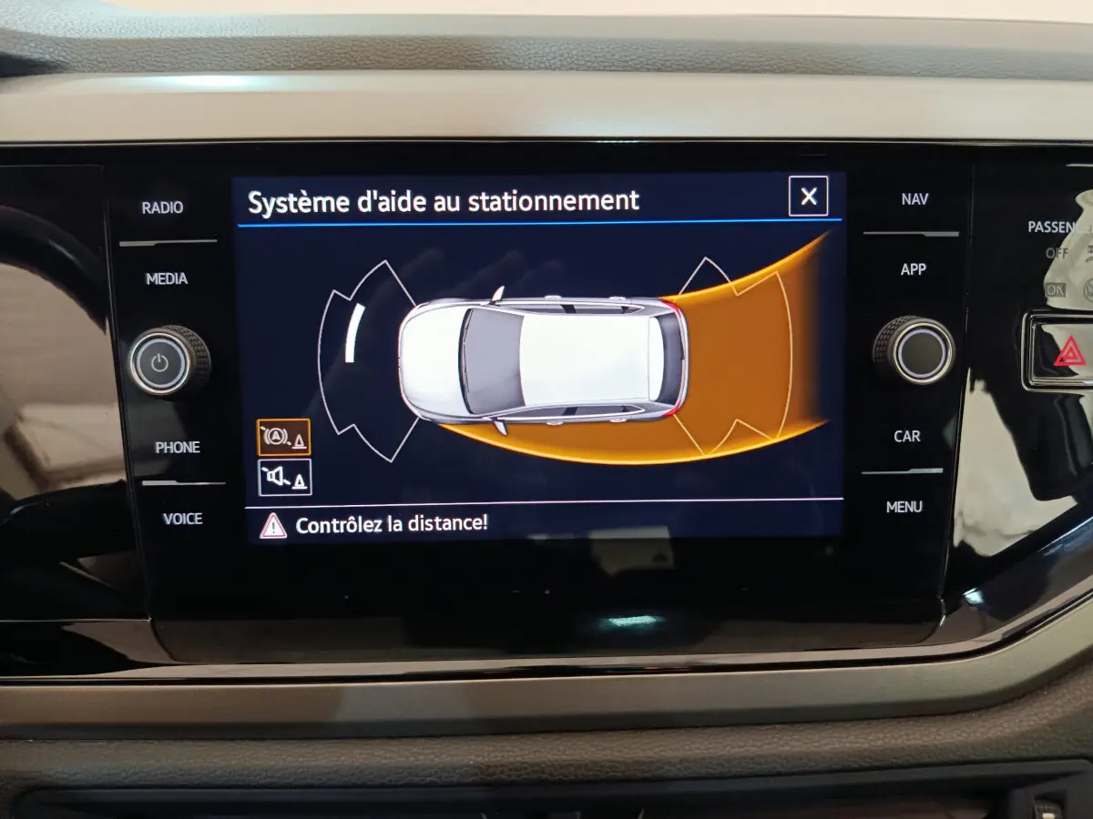 Écran tactile intérieur affichant le système d'aide au stationnement de la Volkswagen Polo blanche 2020.