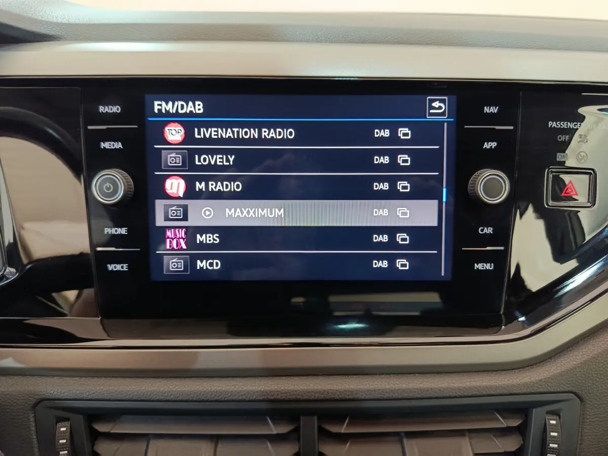 Écran tactile central affichant les stations radio DAB dans l'habitacle d'une Volkswagen Polo blanche 2020.