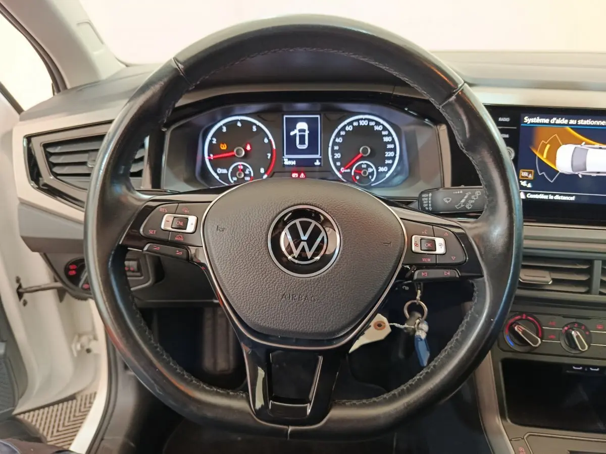Vue rapprochée du volant en cuir noir de la Volkswagen Polo 2020 avec tableau de bord numérique et écran tactile.