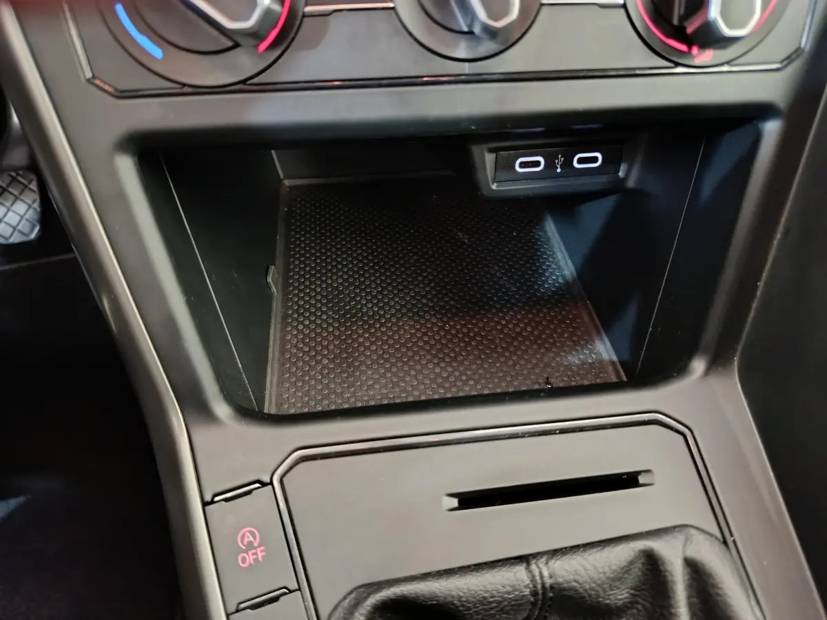 Gros plan sur la console centrale noire avec prise USB et commande désactivation start-stop de la Volkswagen Polo blanche 2020