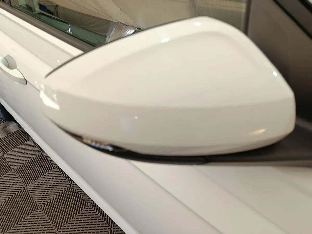 Gros plan sur le rétroviseur côté gauche blanc de la Volkswagen Polo 1.0 TSI 95 Lounge Business 2020.