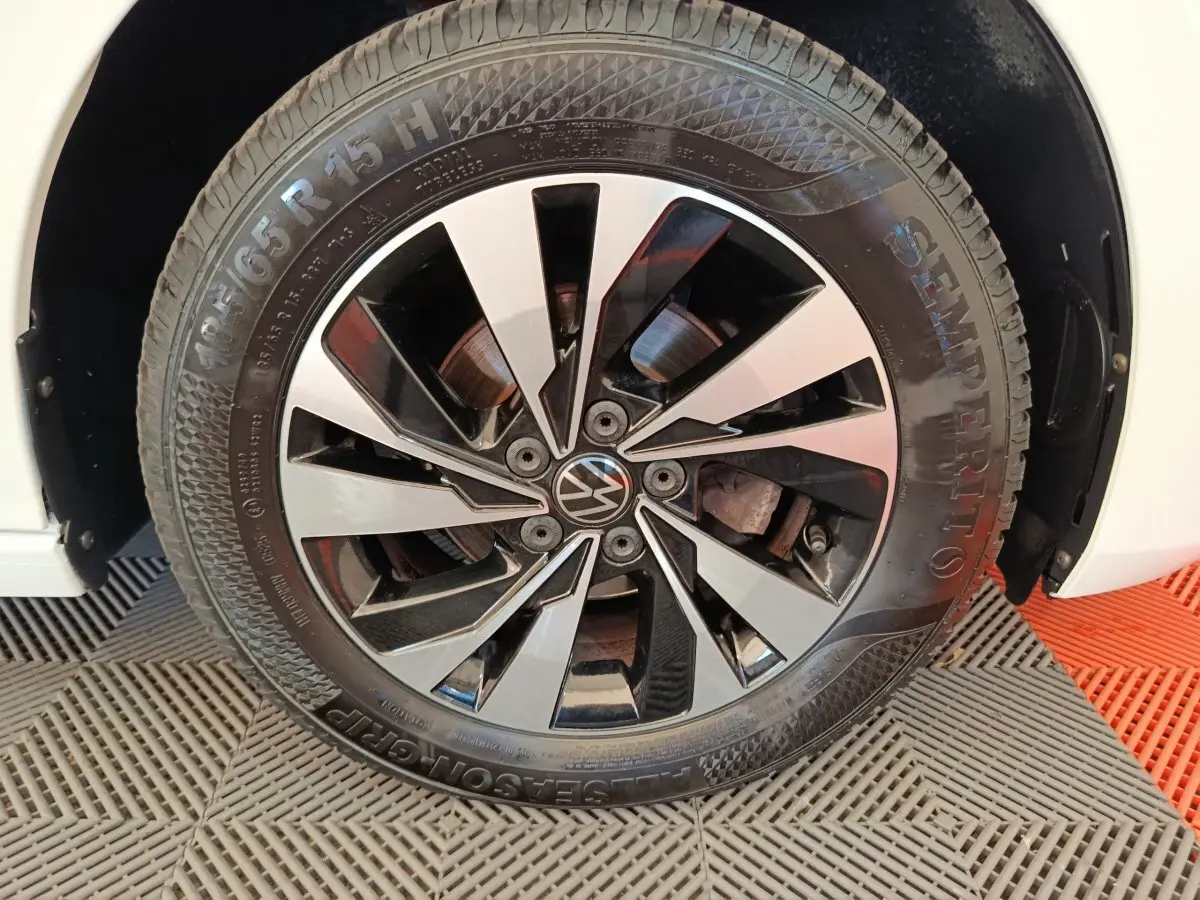 Gros plan sur la roue avant droite blanche d'une Volkswagen Polo 1.0 TSI 95 Lounge Business avec jante alliage noir et argent.