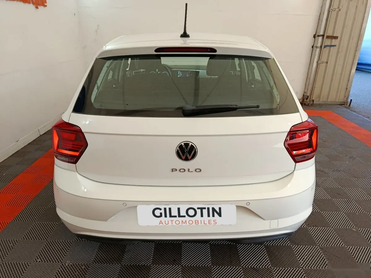 Vue arrière d'une Volkswagen Polo blanche 2020 avec feux arrière rouges et logo VW visible.
