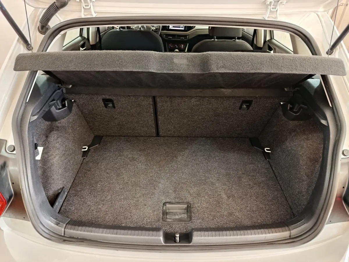 Coffre ouvert vu de l'arrière d'une Volkswagen Polo blanche 2020, montrant l'espace de rangement et la tablette amovible.