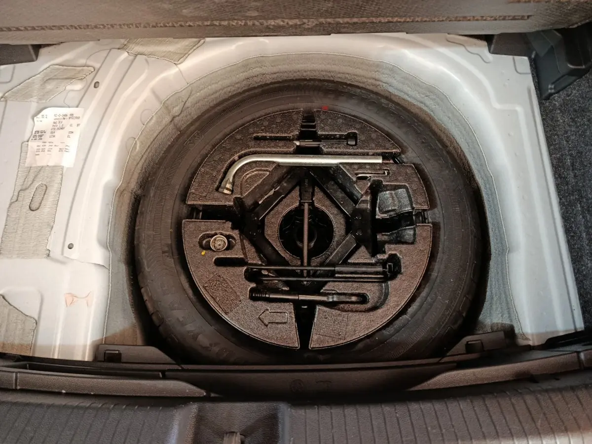 Gros plan sur la roue de secours et les outils de bord dans le coffre d'une Volkswagen Polo blanche 2020.