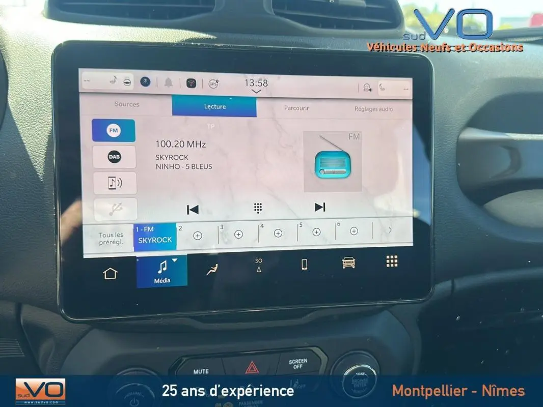 Gros plan sur l'écran tactile multimédia du Jeep Renegade noir 2024 affichant la radio FM Skyrock.