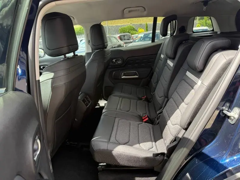 Vue intérieure côté droit des sièges arrière noirs du Citroën C5 Aircross 2025 hybride, avec garnitures tissu et cuir.