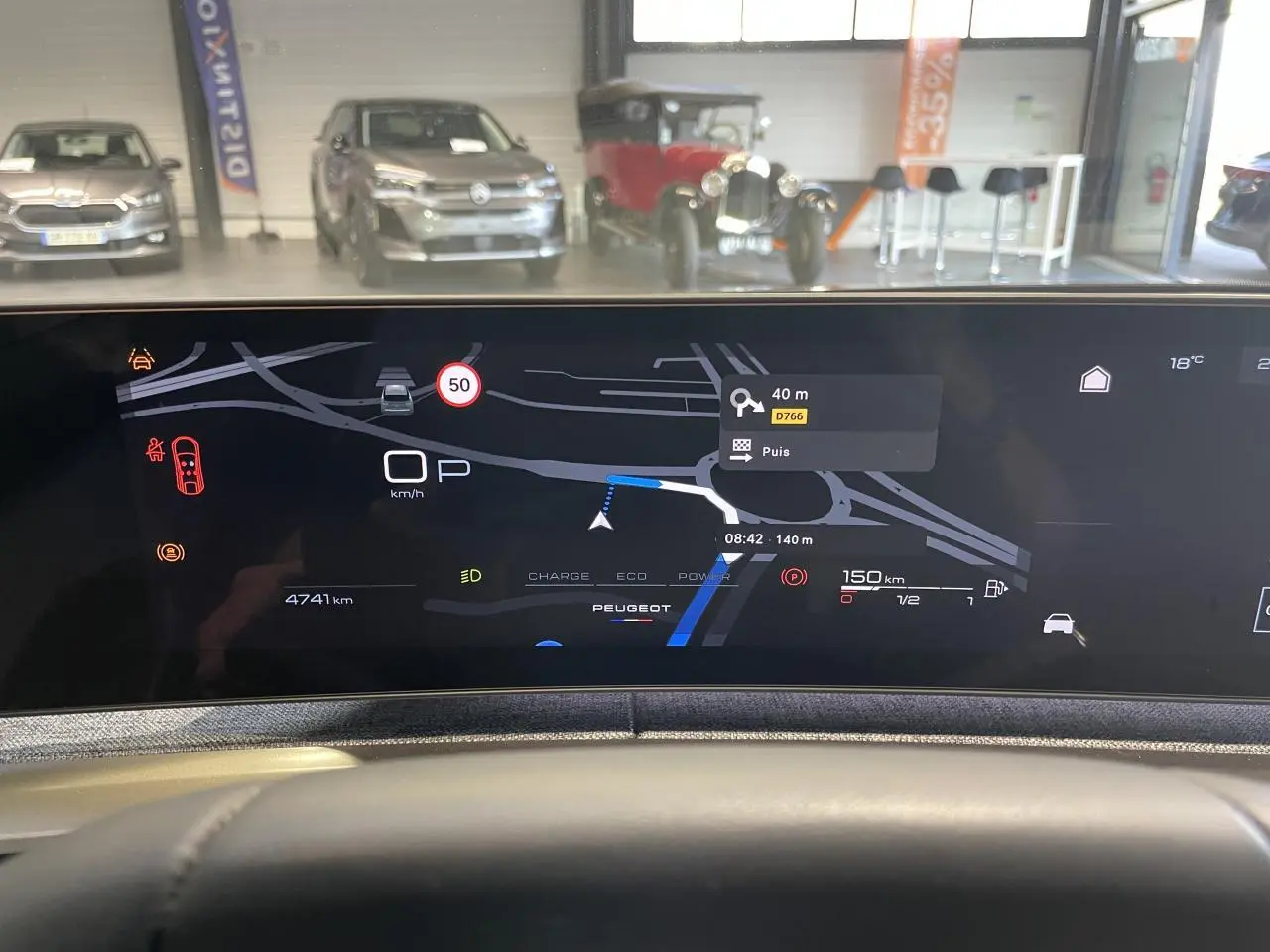 Vue intérieure du tableau de bord numérique du Peugeot 3008 hybride, affichant la navigation et les alertes de conduite.