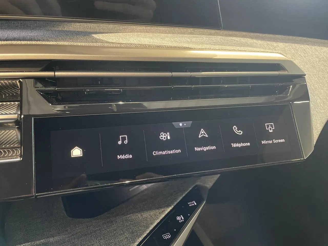 Écran tactile central et commande de climatisation dans l’habitacle du Peugeot 3008 hybride 2025 gris foncé.