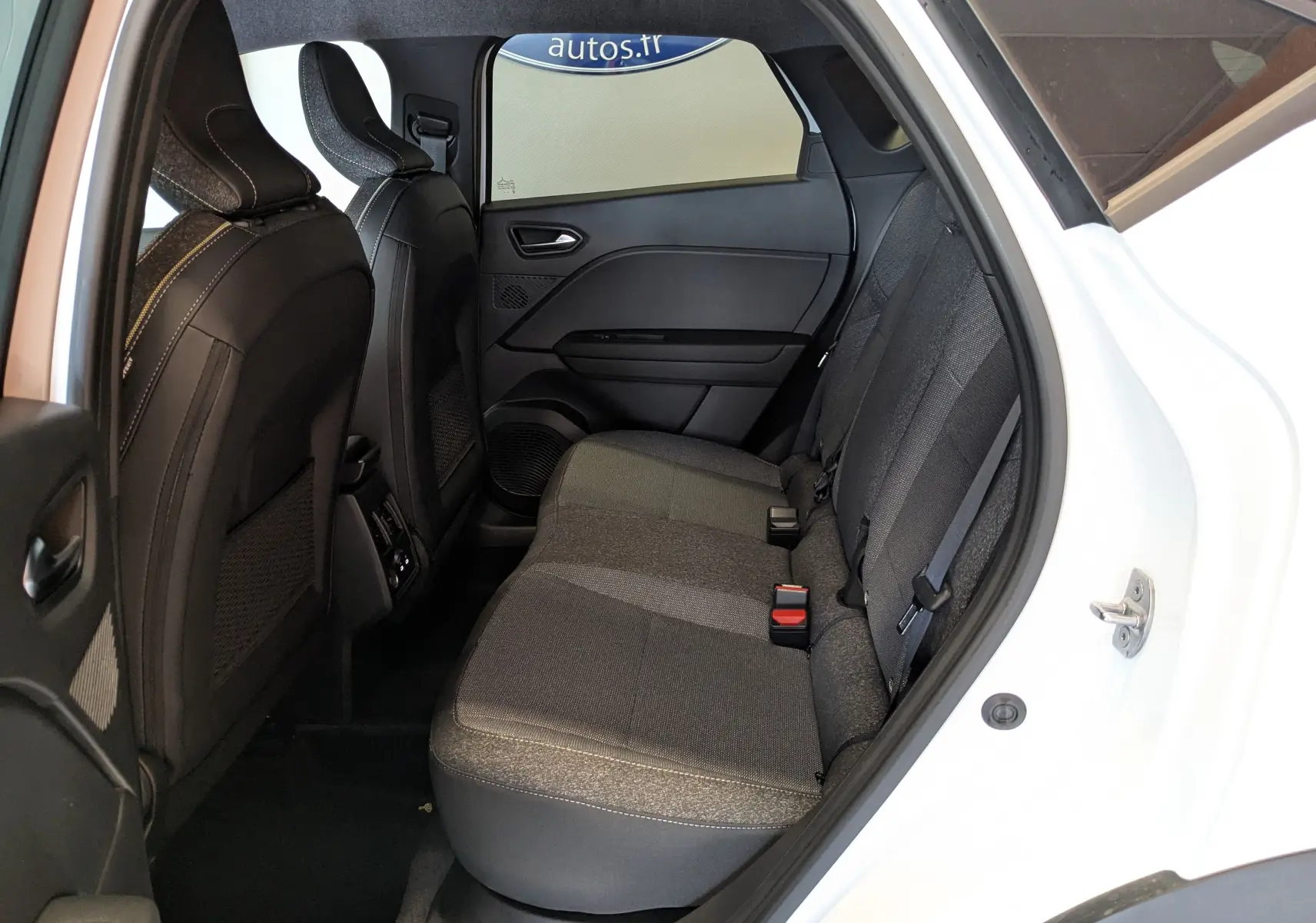 Vue intérieure côté droit des sièges arrière noirs du Renault Captur E-Tech blanc nacré avec toit noir, modèle 2025.