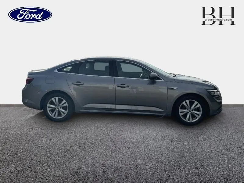 Profil côté droit de la Renault Talisman gris Cassiopée 2016, berline élégante avec jantes alliage et lignes fluides.