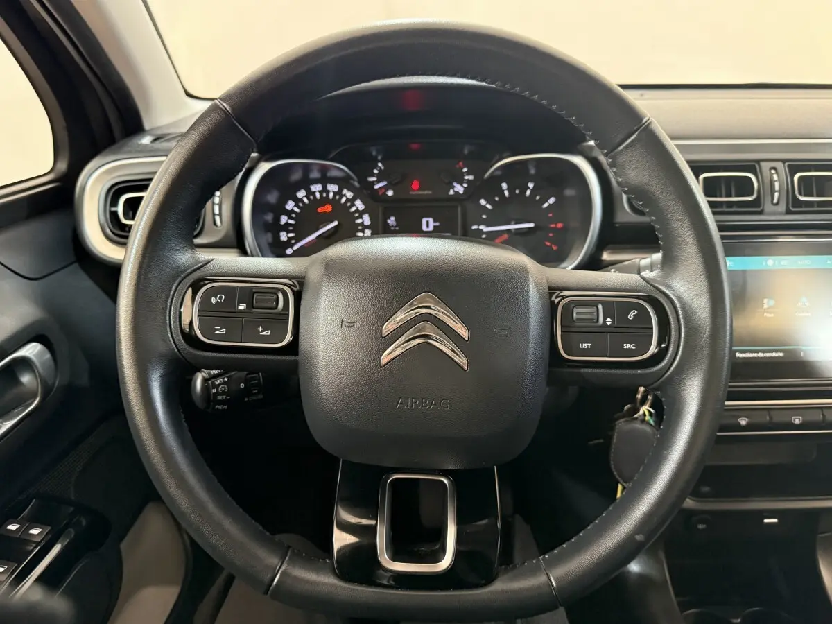 Volant cuir noir de Citroën C3 2019 vu de face, avec commandes intégrées et tableau de bord lumineux.