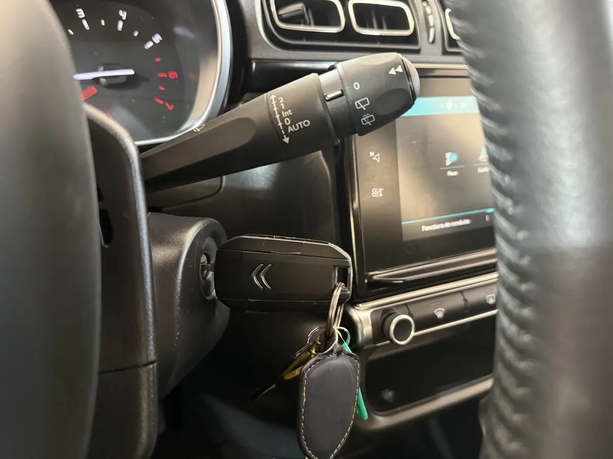 Gros plan sur le neiman avec clé Citroën insérée dans le tableau de bord noir de la C3 Shine Business 2019.