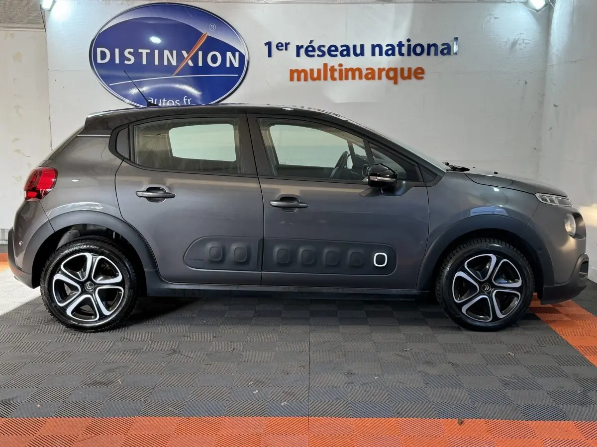 Profil côté gauche d'une Citroën C3 gris clair 2019 avec protections latérales noires et jantes alliage.