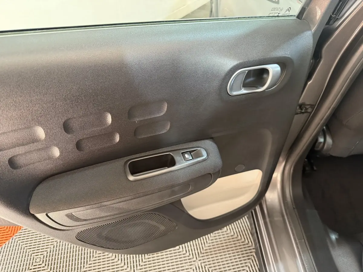 Vue rapprochée de la porte arrière droite gris clair de la Citroën C3 2019 avec poignée et commande de vitre électrique.