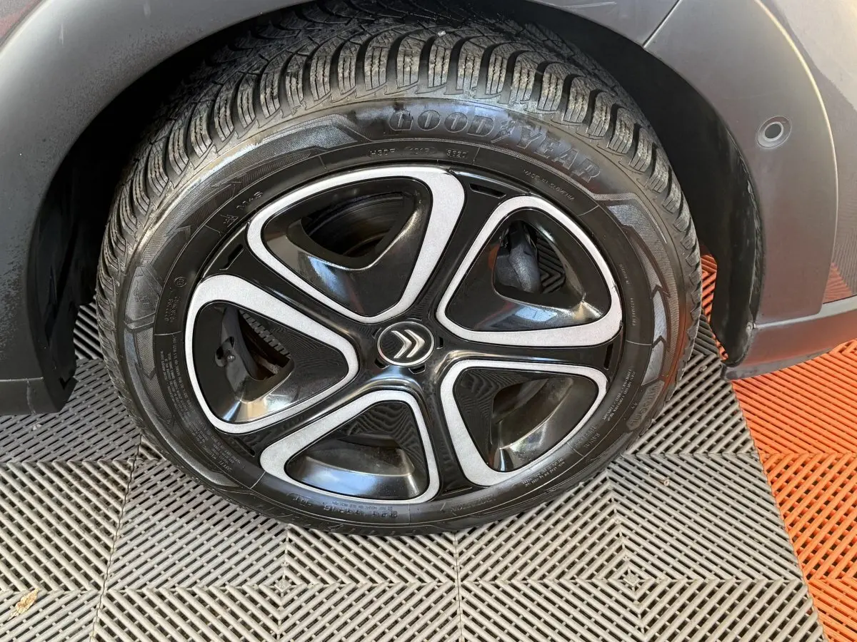 Gros plan sur la roue arrière droite d'une Citroën C3 gris clair, avec passage de roue et partie de la carrosserie visibles.