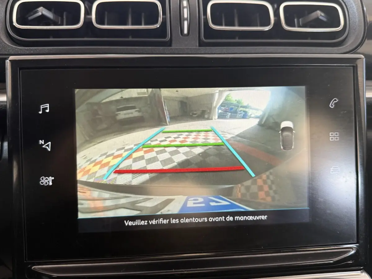 Écran tactile intérieur montrant la caméra de recul avec guidage coloré sur une Citroën C3 gris clair, version Shine Business.
