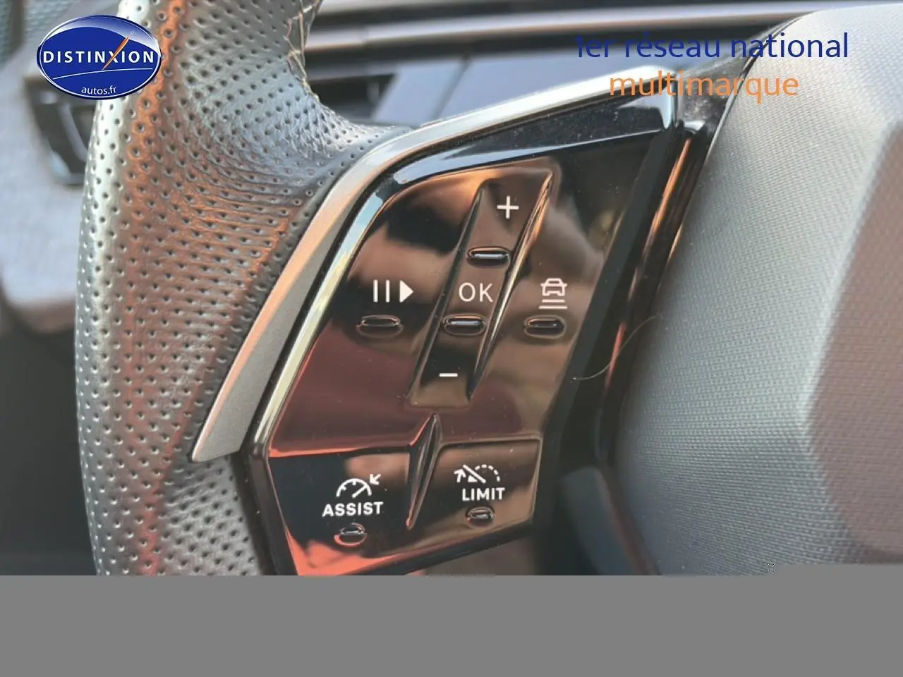 Gros plan sur les commandes multifonctions noires du volant cuir perforé côté gauche du Peugeot 3008 gris 2025.