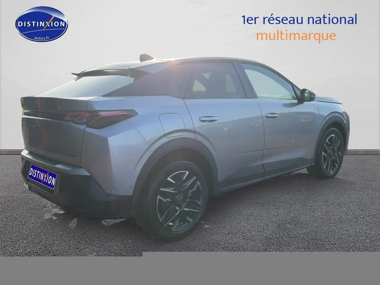 Vue 3/4 arrière droite d'un Peugeot 3008 gris 2025 avec jantes alu noires et becquet arrière distinctif.