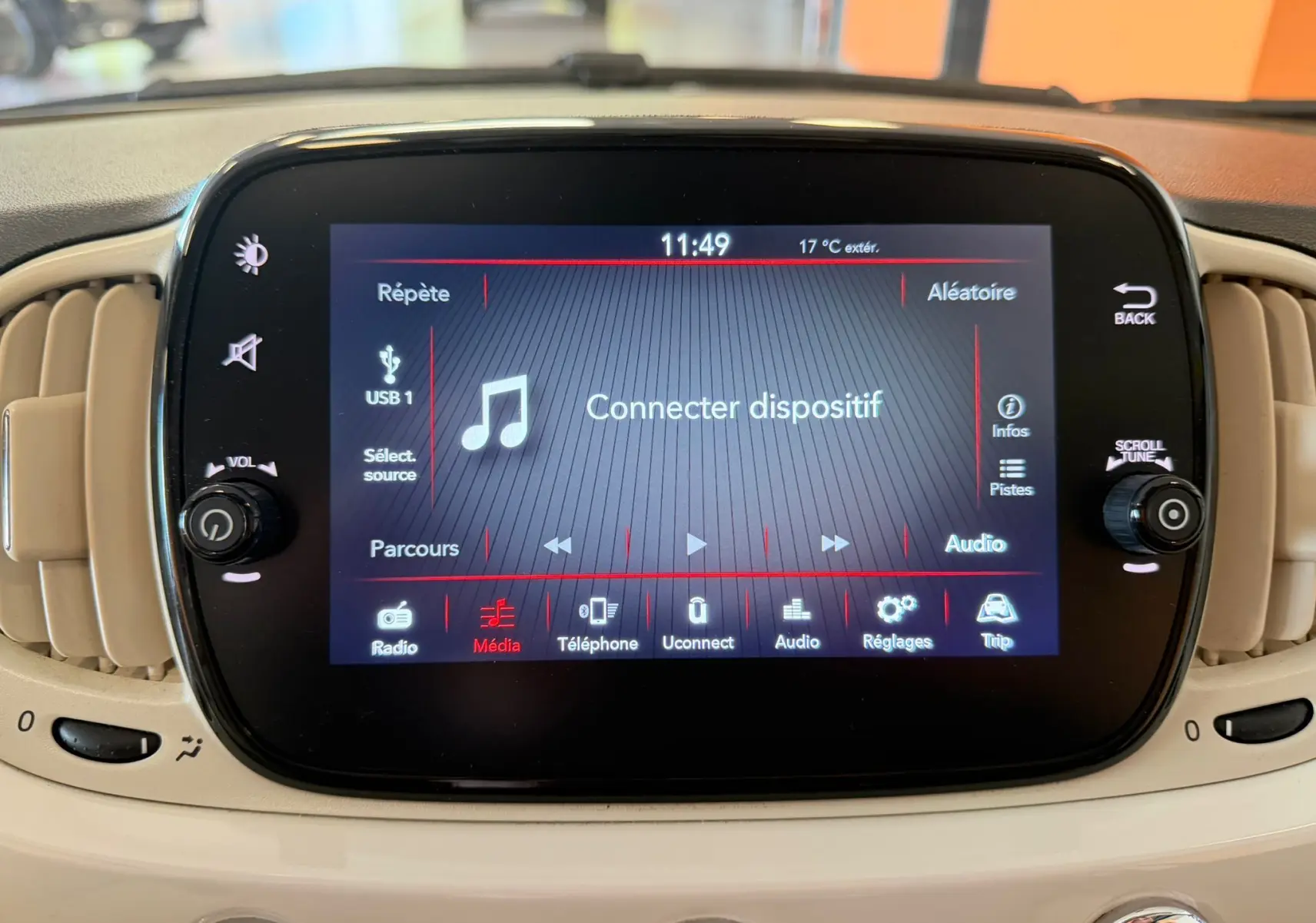Écran tactile central du tableau de bord beige d'une Fiat 500 blanche, affichant le menu média avec option "Connecter dispositif".