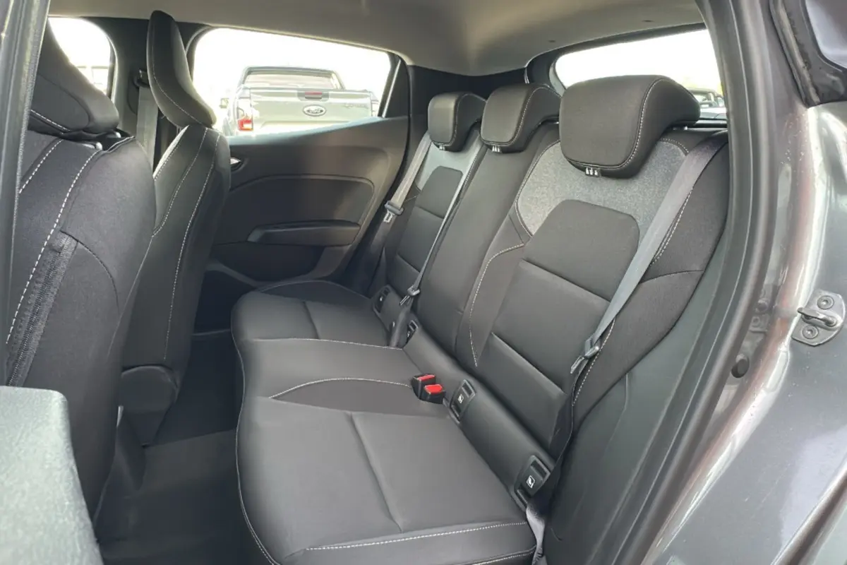 Vue intérieure sur la banquette arrière noire de la Renault Clio gris schiste, avec ceinture et appuie-têtes visibles.