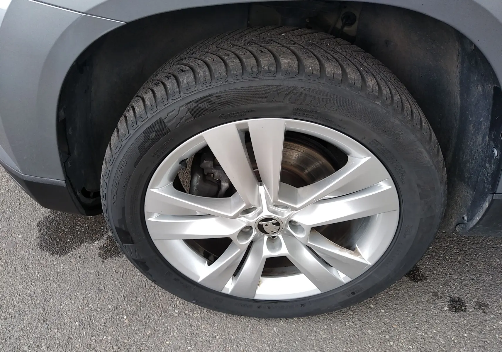 Gros plan sur la roue avant gauche grise d'un Skoda Karoq 2.0 TDI 150ch 4x4 DSG7 Style, jante alliage 18 pouces.