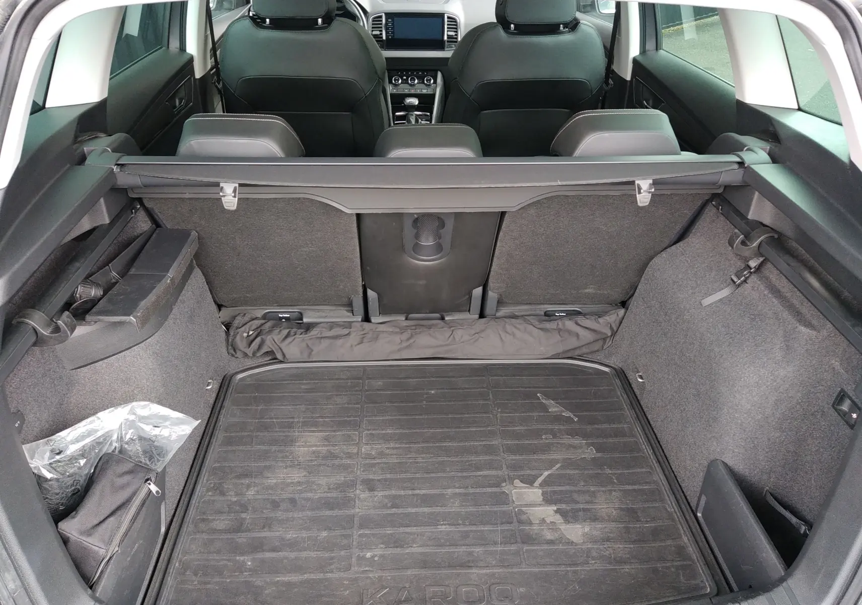 Vue intérieure du coffre gris du Skoda Karoq 2022, avec banquette arrière et tablette cache-bagages visibles.