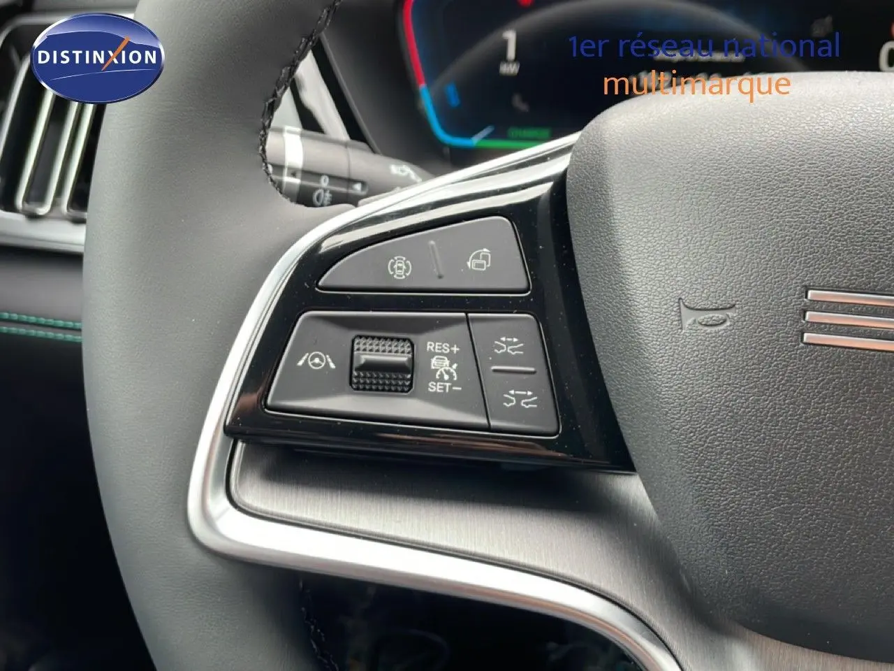 Gros plan sur les commandes gauche du volant noir du BYD SEAL U 2026, avec boutons de régulateur et aides à la conduite.
