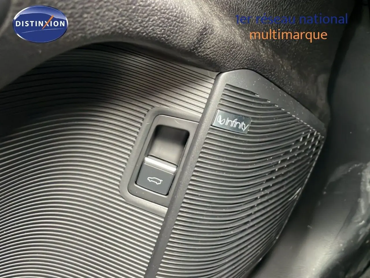 Gros plan sur le bouton d'ouverture du coffre avec haut-parleur Infinity intégré, intérieur noir du BYD SEAL U 2026.