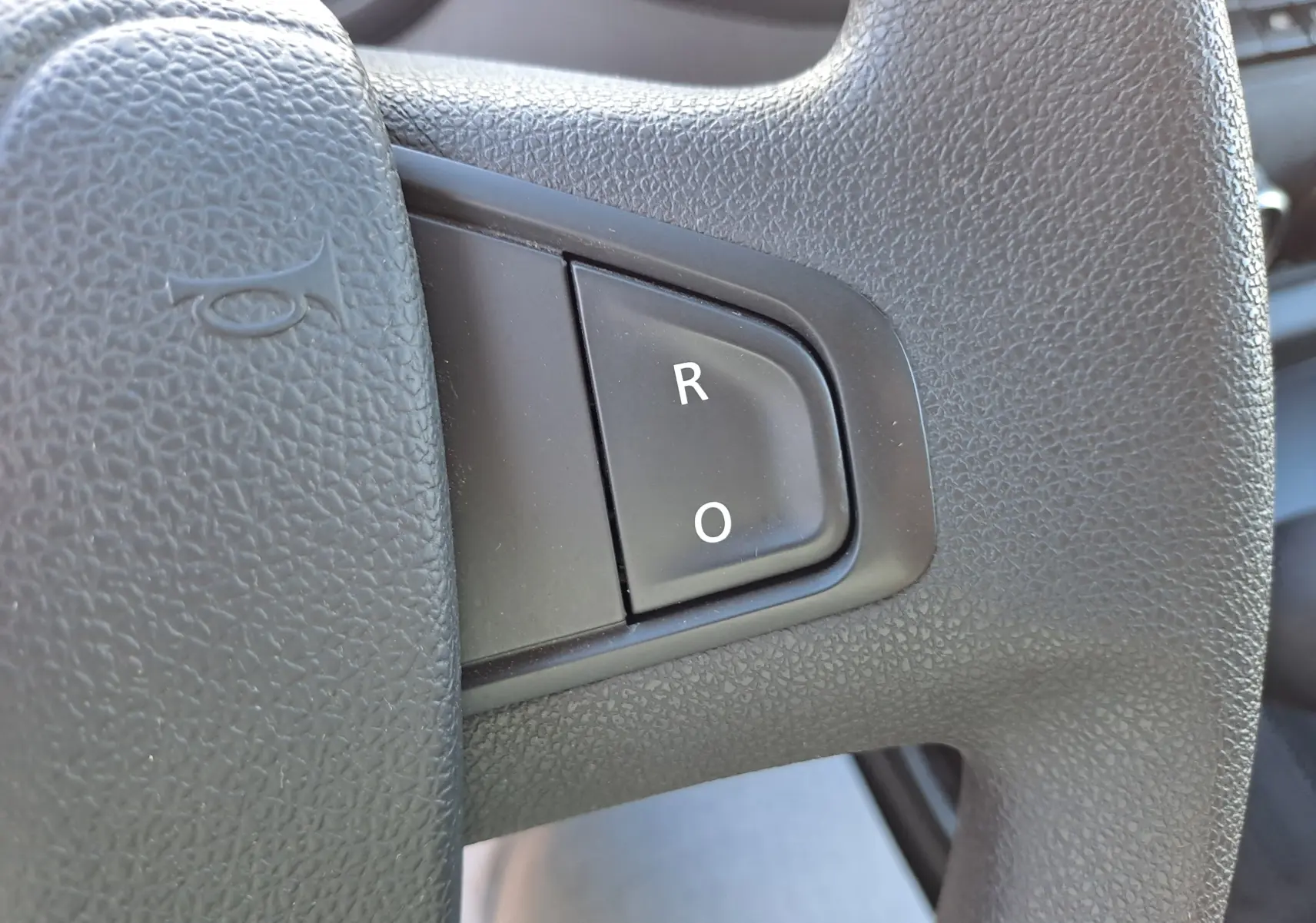 Détail du volant noir du Nissan Interstar Chassis Cabine 2024 montrant les boutons R et O sur la partie droite.