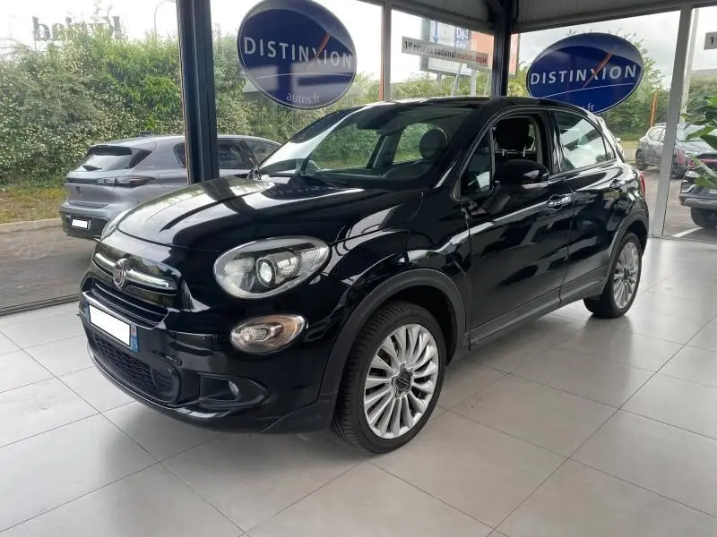Vue 3/4 avant droite d'une Fiat 500X noire brillante avec jantes alliage dans un showroom lumineux