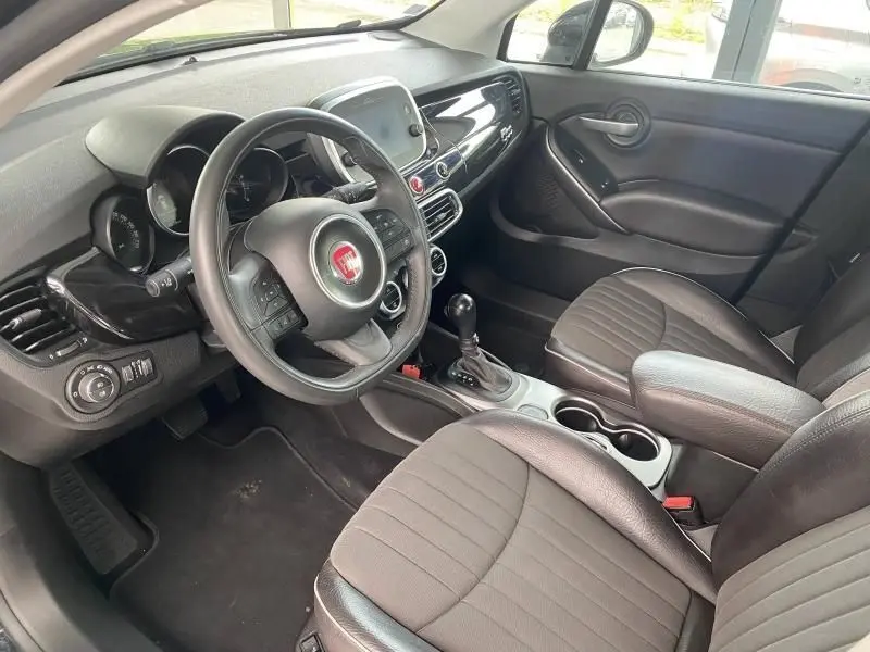 Intérieur noir de la Fiat 500X 2018, vue côté conducteur, volant multifonction et console centrale avec boîte auto.