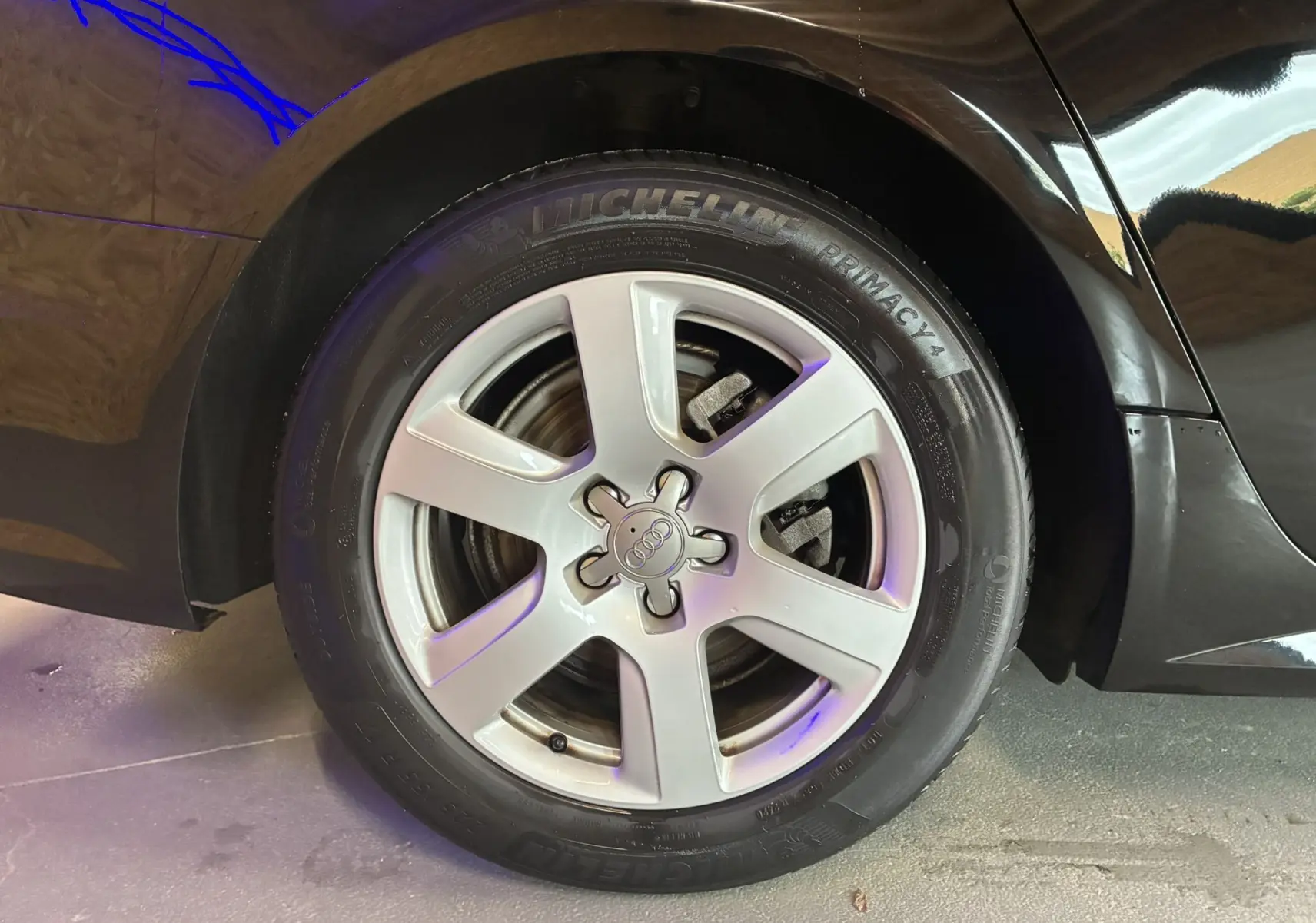 Gros plan sur la roue arrière droite noire d'une Audi A6 Avant 2017 avec jante argentée cinq branches.