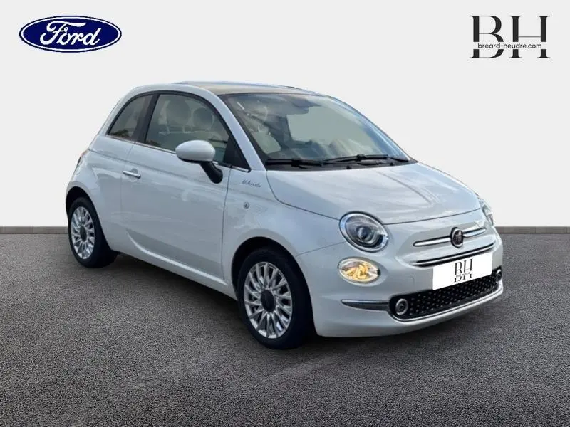 Fiat 500 blanche Bossa Nova vue 3/4 avant droit avec phares allumés sur fond neutre.