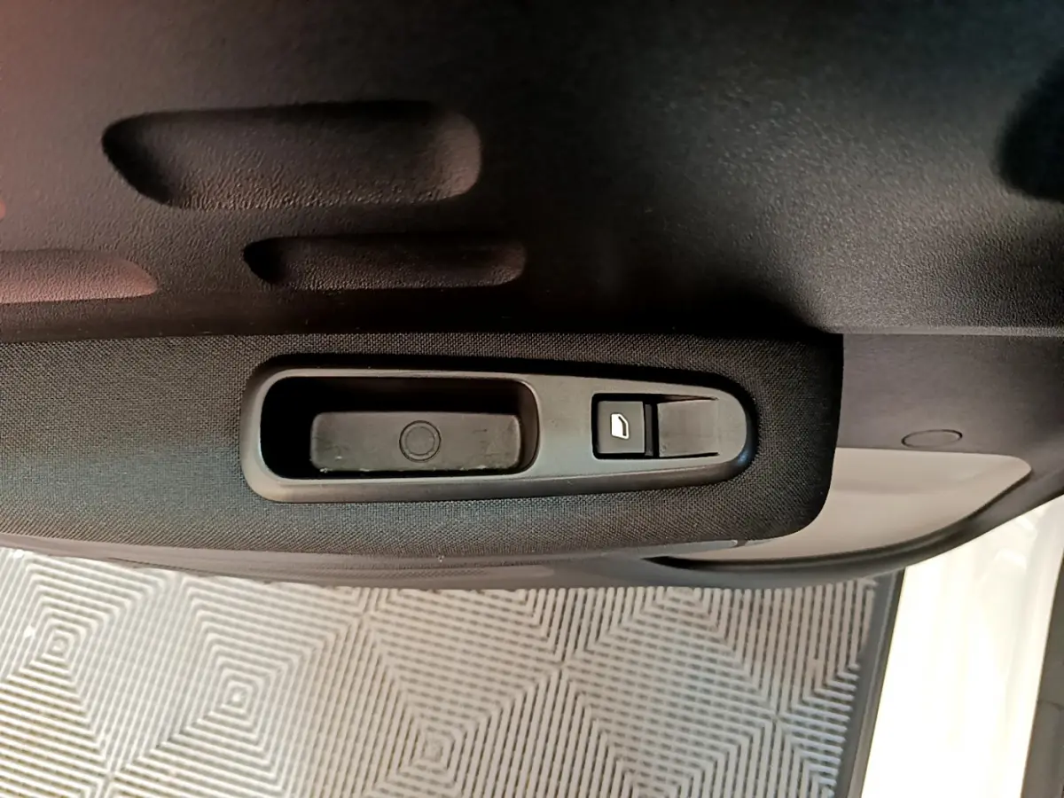 Poignée intérieure de porte côté gauche de la Citroën C3 blanche, avec bouton de verrouillage visible.