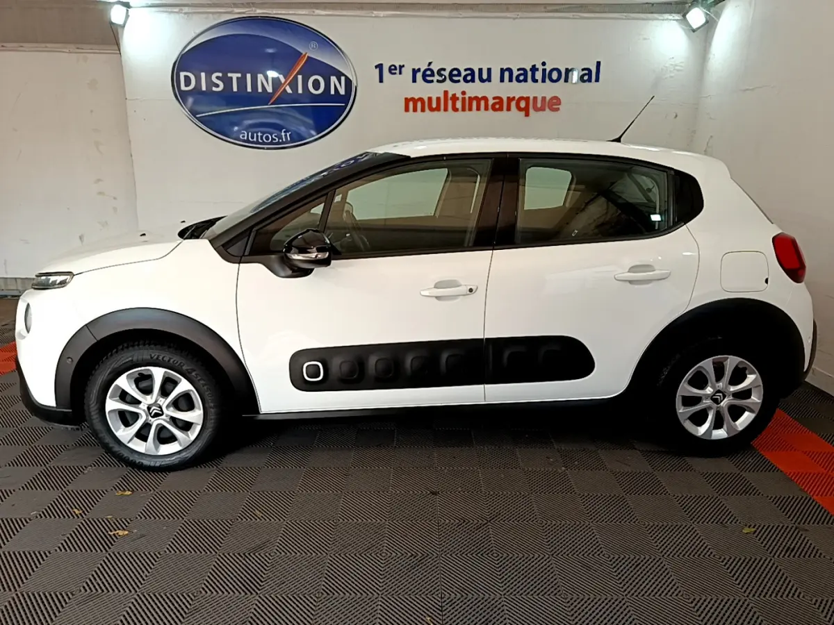 Profil côté gauche d'une Citroën C3 blanche 2019 avec protections noires caractéristiques et jantes alliage.