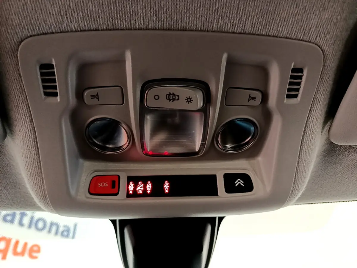 Vue en gros plan du plafonnier intérieur gris avec boutons d'éclairage et alerte ceintures de la Citroën C3 blanche 2019.
