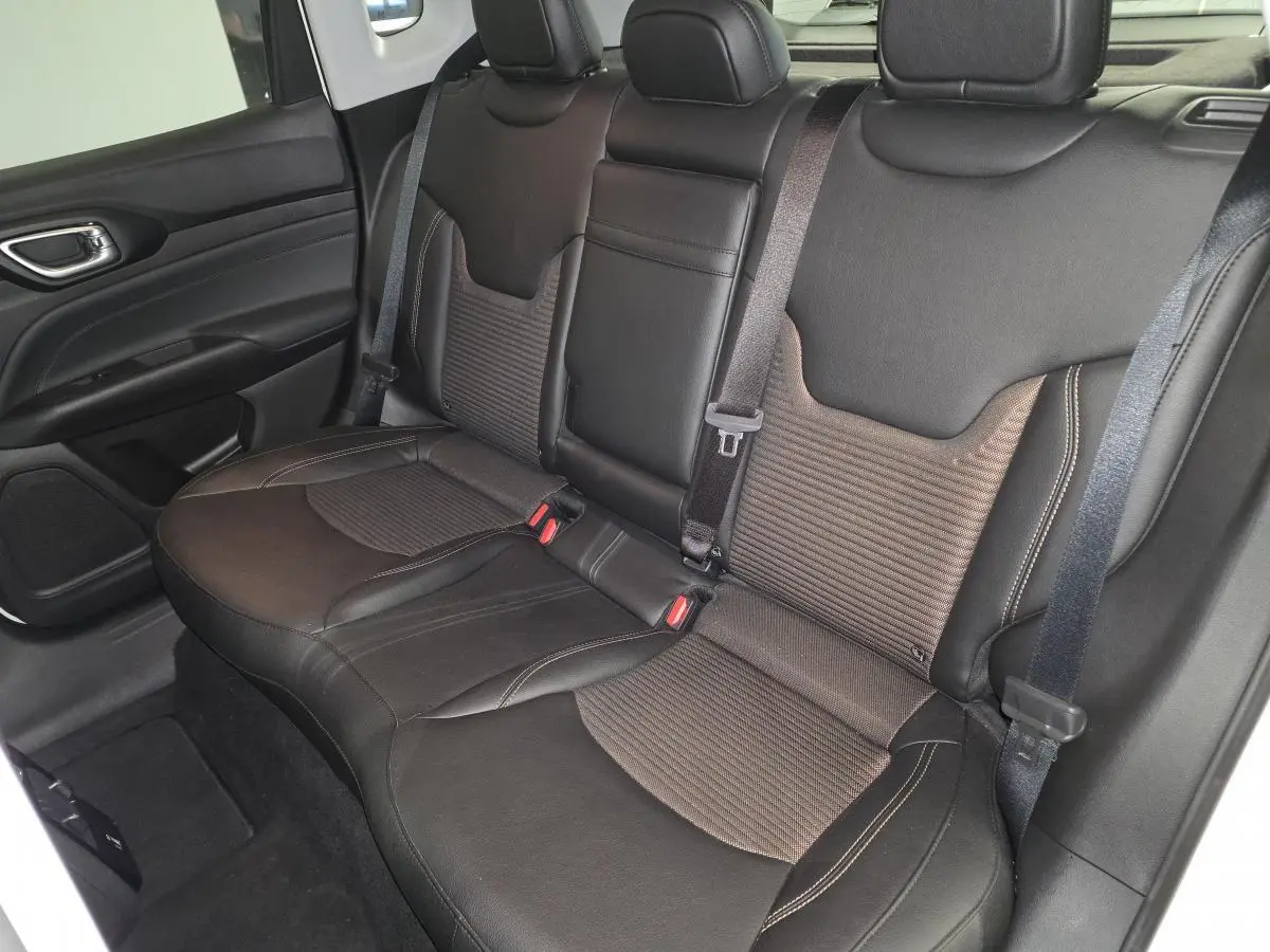 Vue intérieure côté droit sur la banquette arrière noire et bronze du Jeep Compass 2024 avec ceinture de sécurité visible.