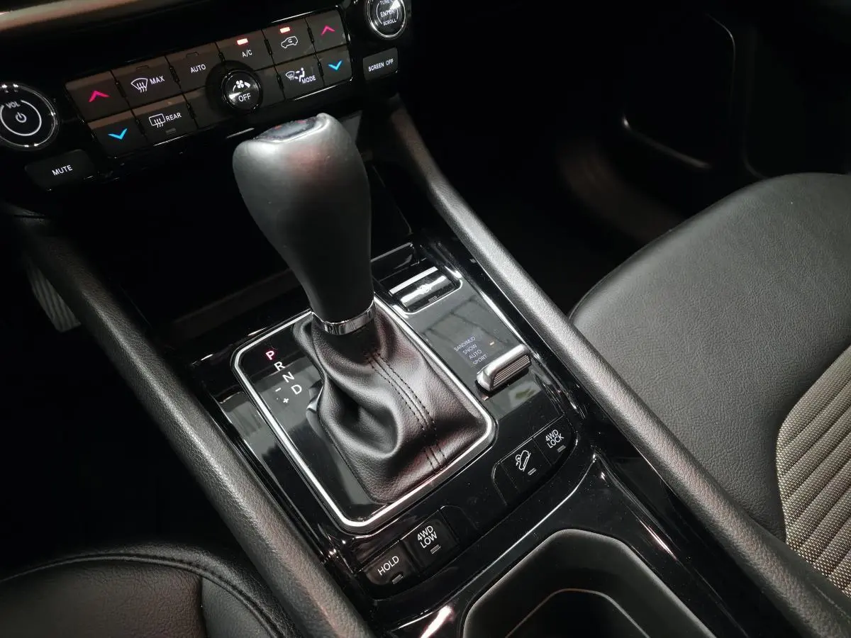 Gros plan sur la console centrale noire avec levier de vitesses automatique et commandes 4WD du Jeep Compass blanc 2024.