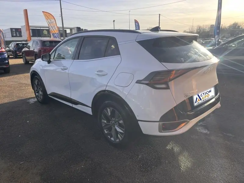 Vue 3/4 arrière droite du Kia Sportage blanc nacré avec jantes alliage et feux arrière LED distinctifs.