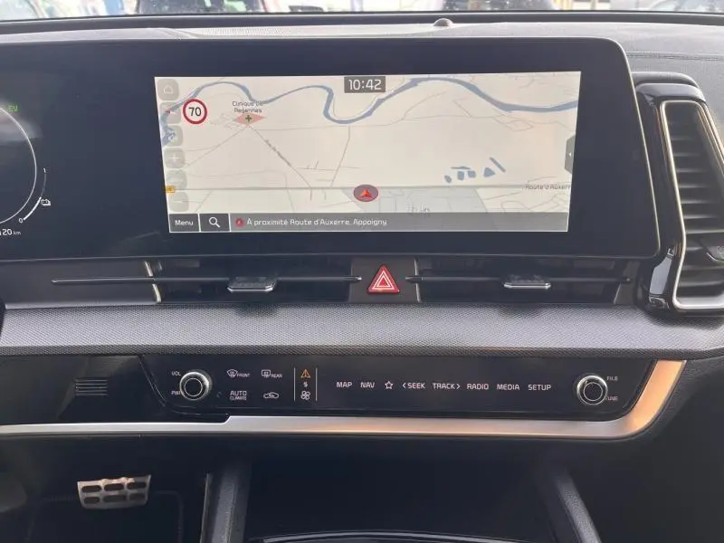 Vue rapprochée de l'écran tactile central et de la console du Kia Sportage 2022, affichant la navigation GPS.