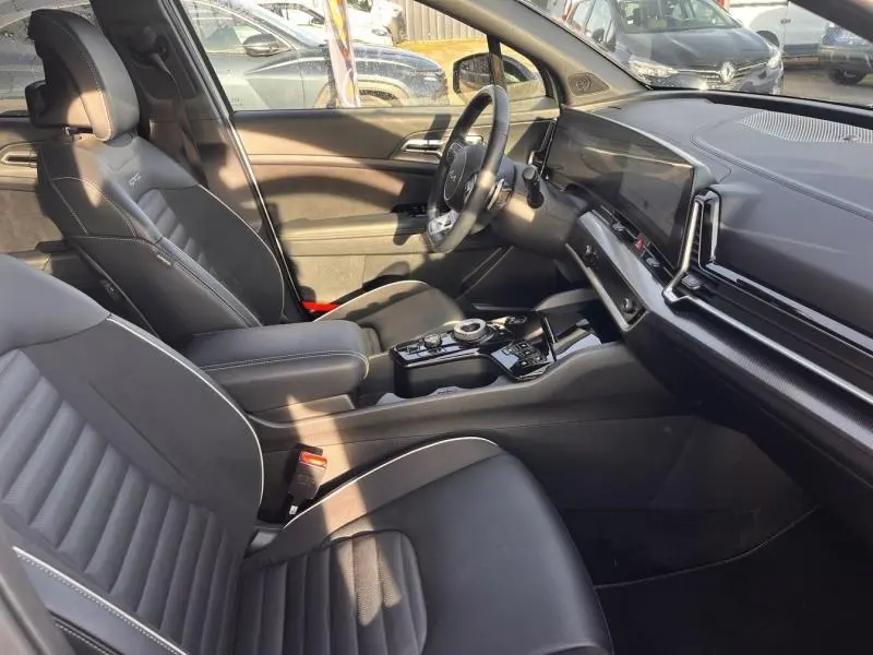 Intérieur avant du Kia Sportage 2022 GT-Line Premium, sièges noirs cuir/suède et tableau de bord avec écran tactile panoramique.