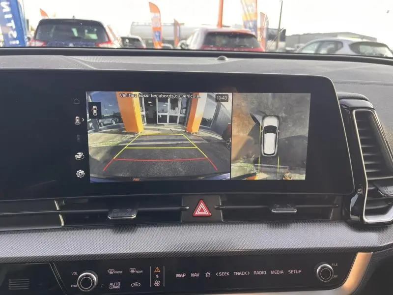 Écran multimédia affichant la caméra de recul et vue panoramique 360° du Kia Sportage blanc nacré, vue intérieure avant.