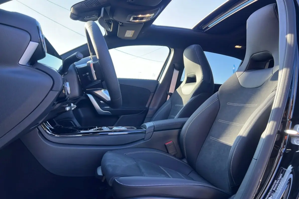 Vue intérieure côté conducteur de la Mercedes Classe A 200D Exclusive Design avec sièges sport cuir et toit ouvrant panoramique.