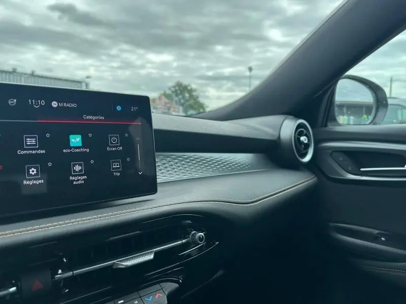 Vue intérieure côté passager de l'Alfa Romeo Tonale 2025 blanc Monterosa, avec écran tactile et aérateurs ronds.