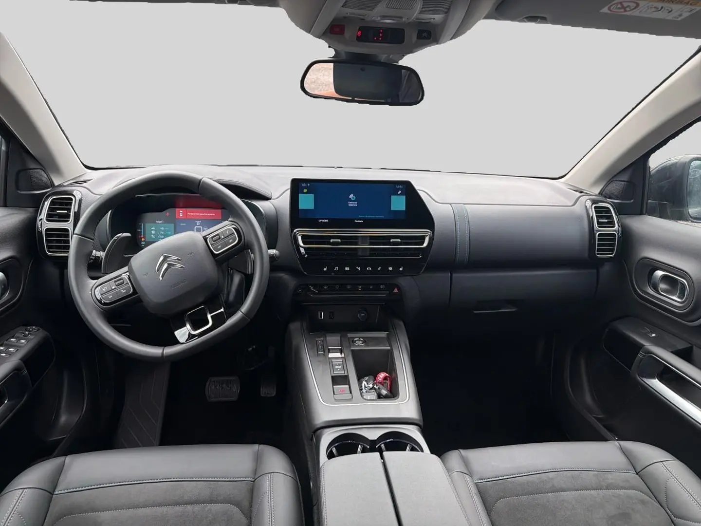 Vue intérieure avant du Citroën C5 Aircross 2024 noir, volant cuir multifonction et écran tactile central visible.