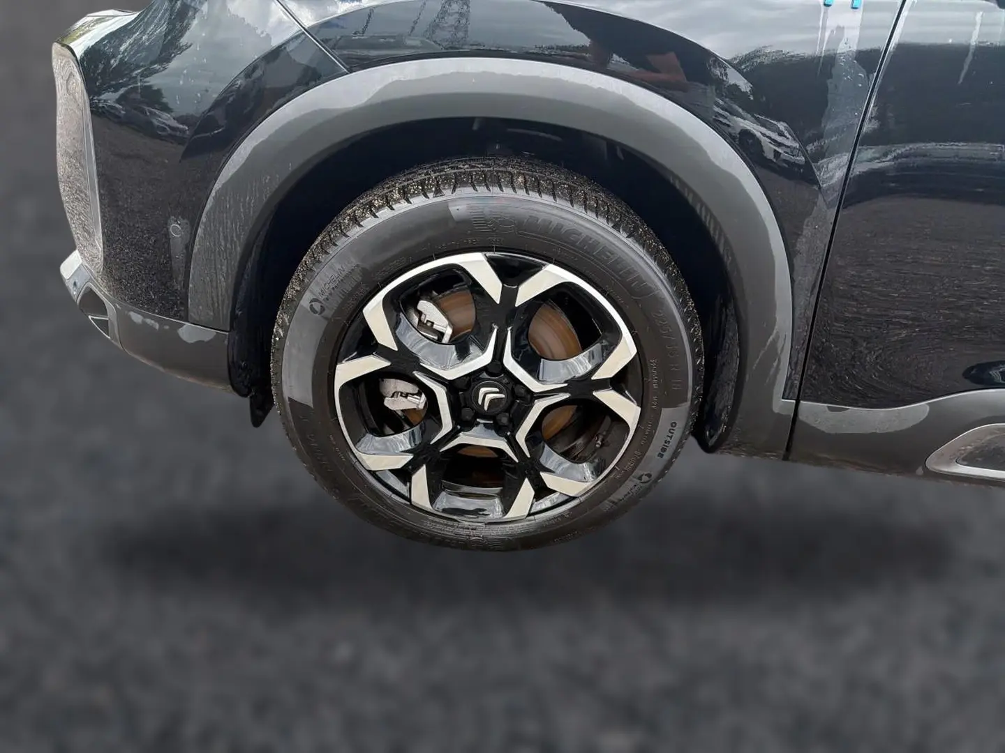 Gros plan sur la roue avant gauche noire du Citroën C5 Aircross 2024 avec jante alu bicolore distinctive.